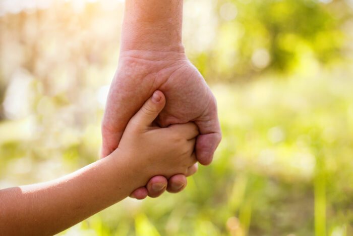 A sea change in adoption: prioritising the lifelong needs of adopted people 28 Adult and child holding hands