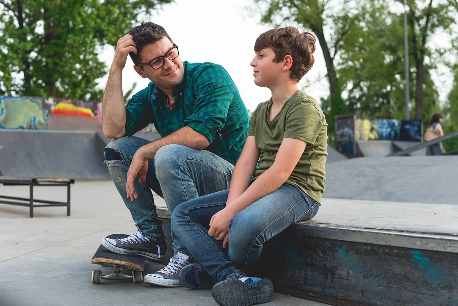 Father having a meaningful conversation with his son at a local skatepark in Sale, Manchester.
