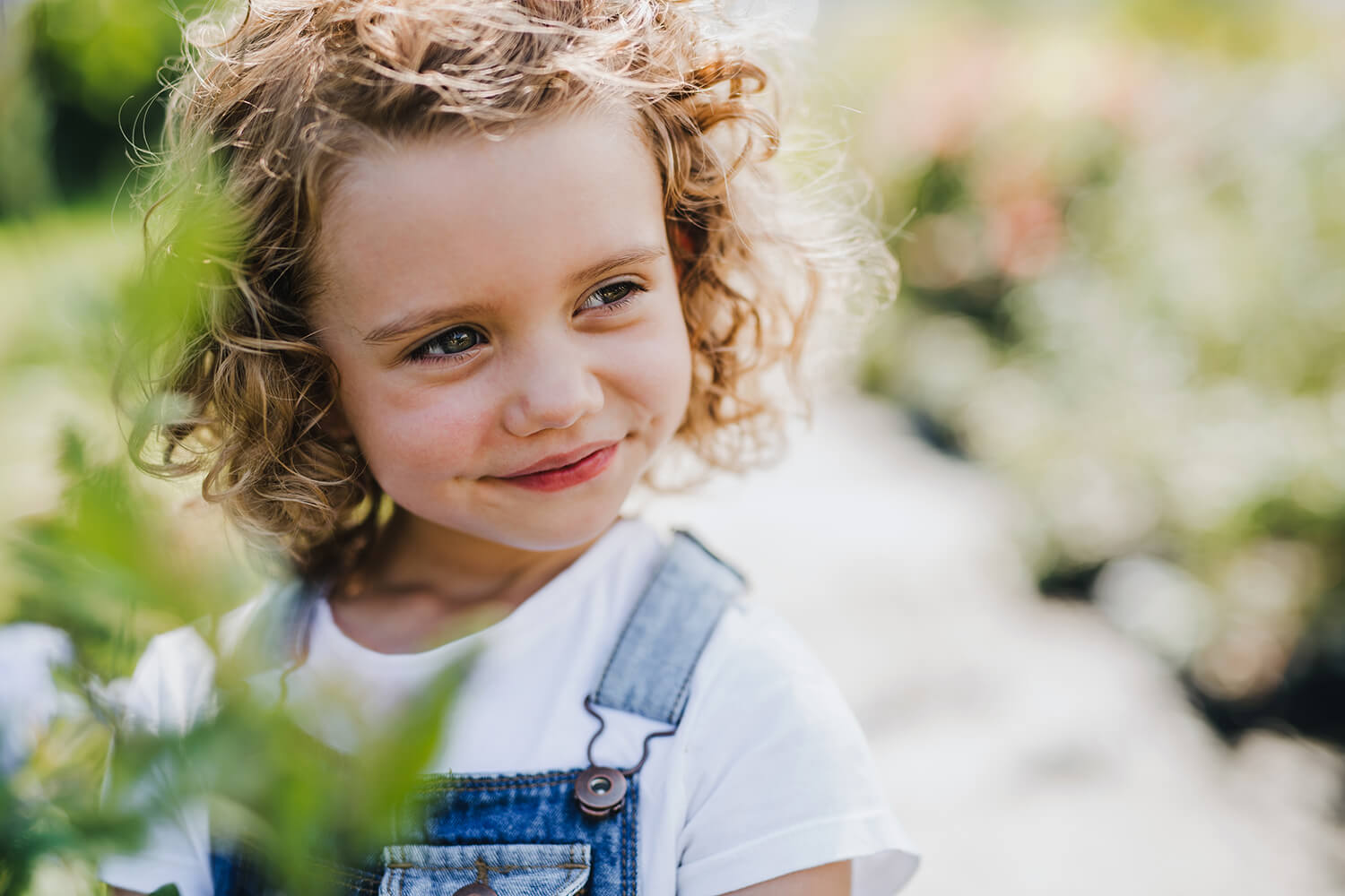 Close-up of a happy young girl with curly hair in a garden, symbolising children’s wellbeing after legal support in Knutsford.